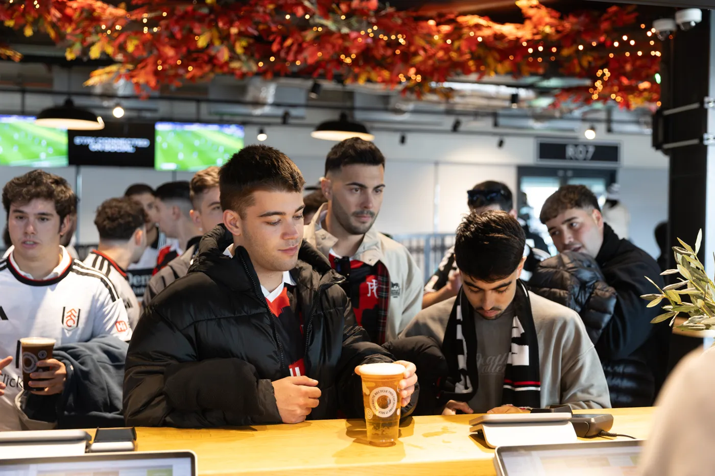 Members of the group at a bar inside the ground before the game